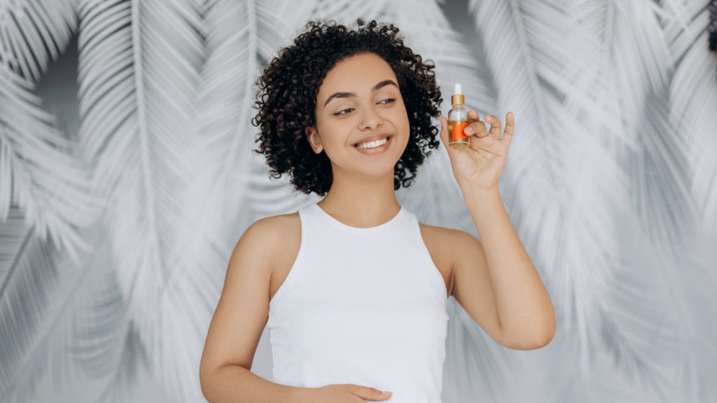 Woman holding CBD oil bottle, branding advice for CBD businesses