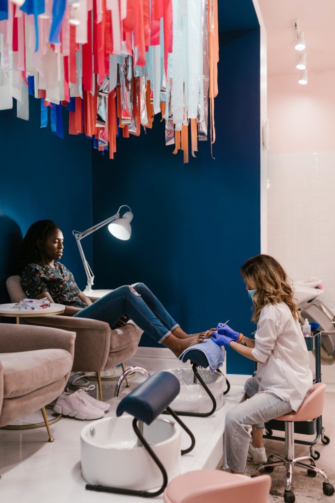 Pedicure service at a salon, nail technician providing foot care.
