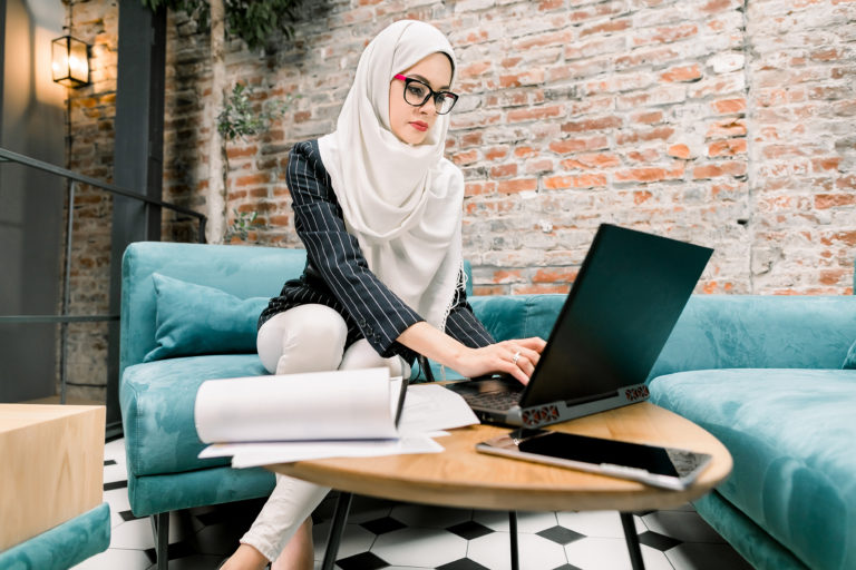 Woman in hijab using laptop for marketing and business advice