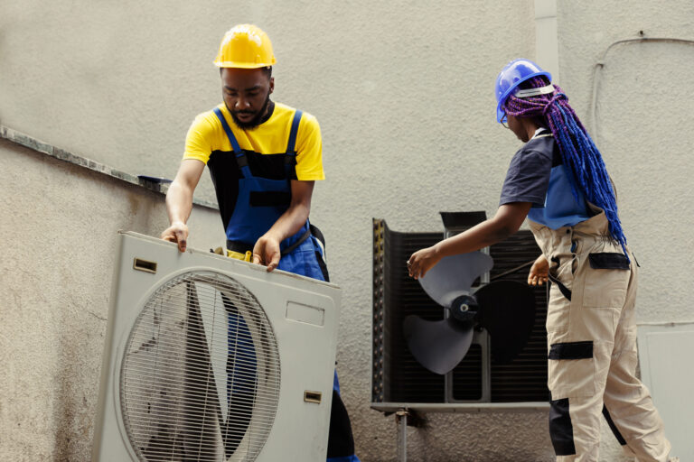 Technician disassembling HVAC unit panel, commercial facility maintenance and business management.