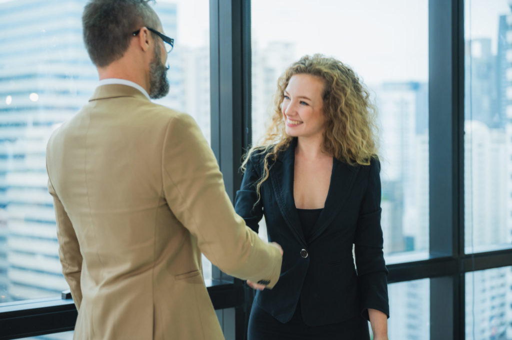 Business professionals shaking hands illustrating leadership and collaboration.