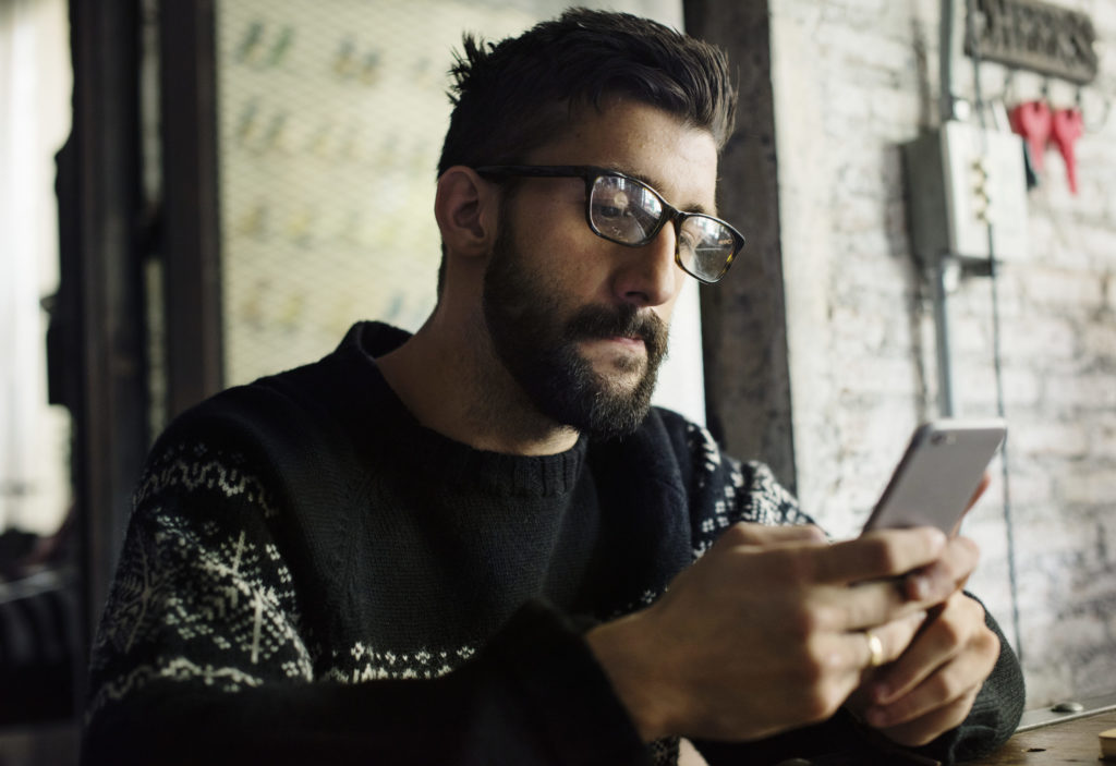 Man using smartphone researching business management and marketing tips