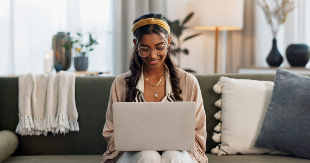 Woman working on laptop at home illustrating tech startup growth.