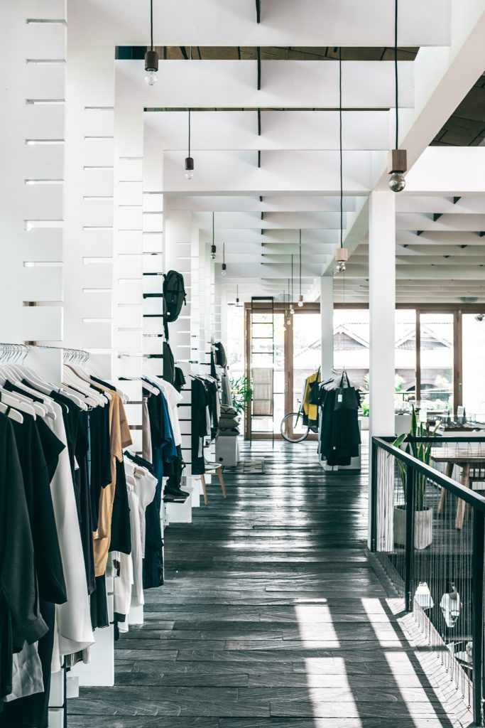 Well-organized retail space with clothing racks and inventory storage solutions.